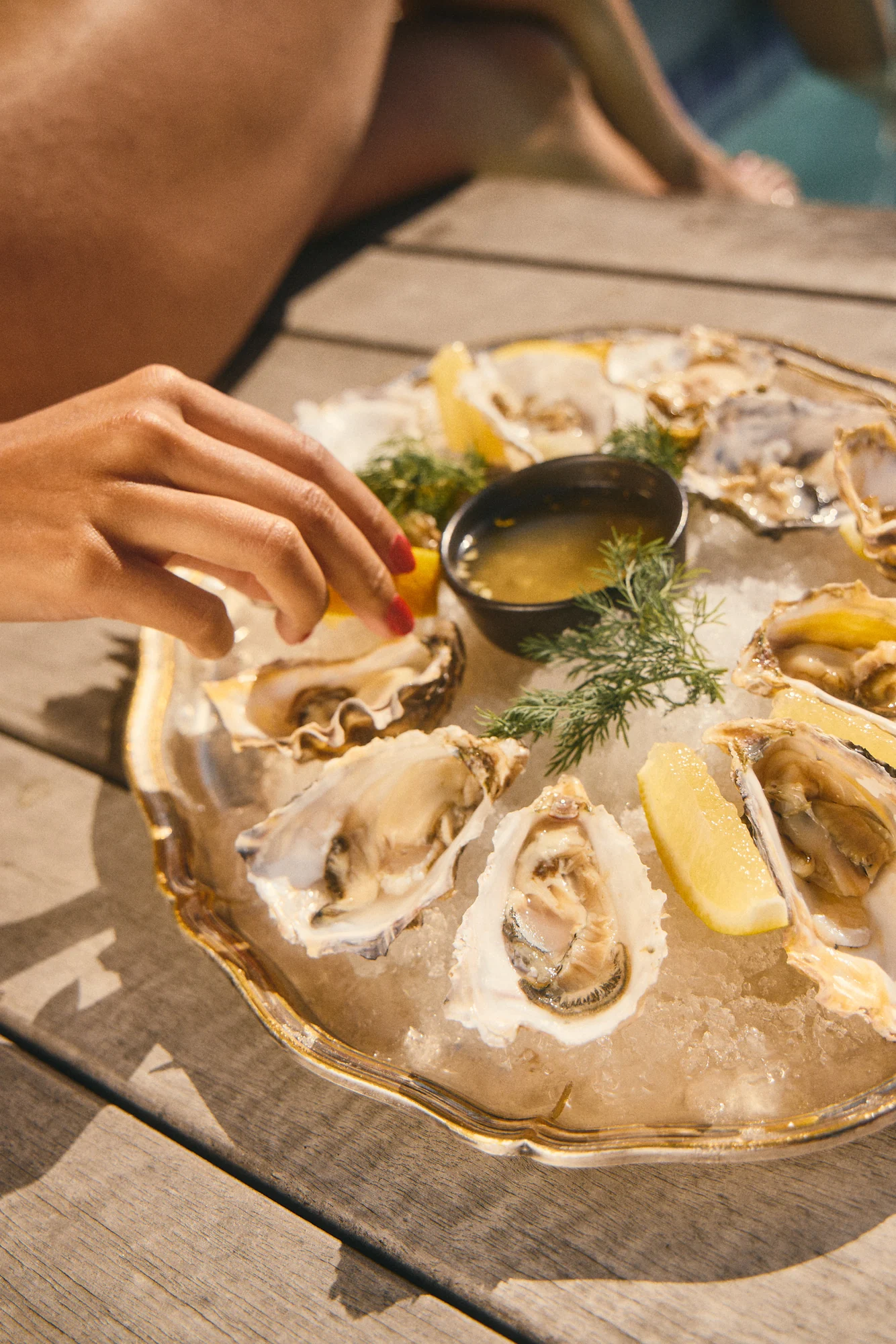 Oysters on ice with lemon and colourful dipping sauces