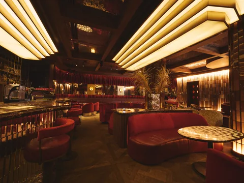 Red leather seating beneath geometric lights at Owner’s Office