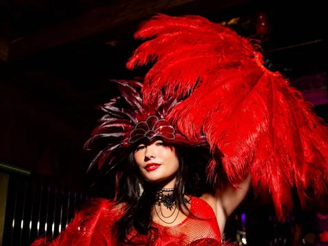 Performer in red feathers at Owner’s Office