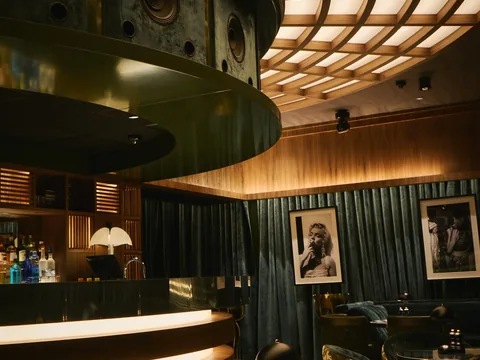 Curved bar beneath a glowing ceiling inside The Room