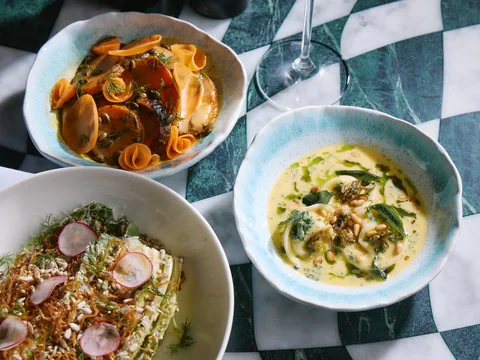 Three plated dishes on a chequered table at The Room
